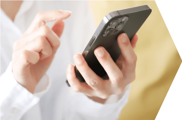 スマートフォンを操作する人の手元（オンラインでの手続きや問い合わせを連想させる）