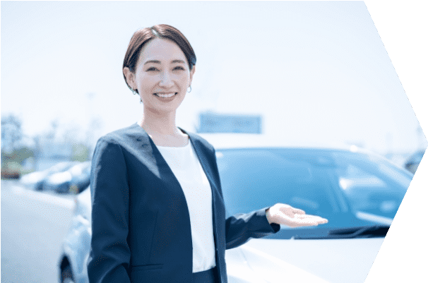 車の前で笑顔で案内する女性スタッフ