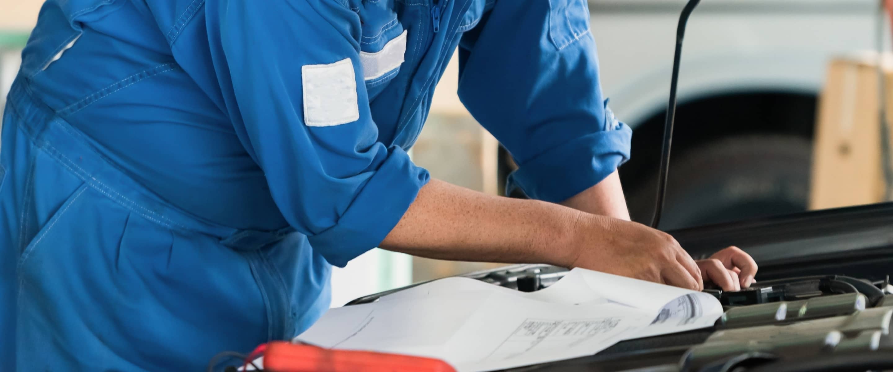 車のエンジンルームを診断するメカニック