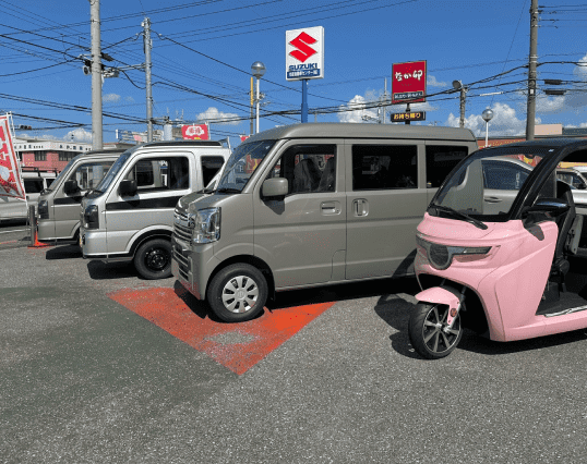軽自動車や電動三輪車が展示されている屋外の販売スペース