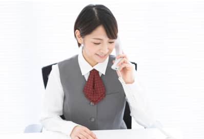 整備士が女性に車のエンジン内部を見せながら説明する場面
