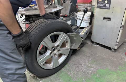 タイヤ交換中の整備士の手元と専用機械